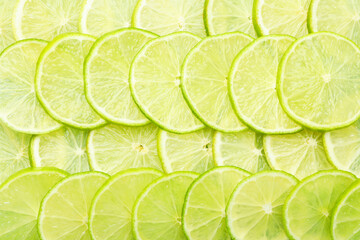 Slices of fresh limes as background, top view