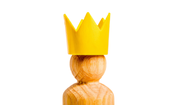 A wooden figure wearing a yellow crown, symbolizing royalty, leadership and authority. The image captures a sense of power and regality