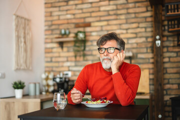 senior mature man enjoy at home while eat salad and drink water
