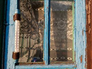 A thermometer is attached to the side of a window
