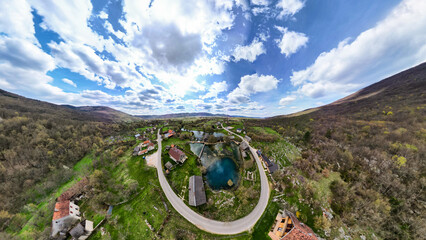 Aerial view of beautiful Gacka river spring in the village of Sinac, Croatia, next to the wooden, rural houses and mills called Majerovo Vrilo