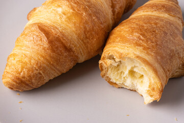 Freshly baked croissants served on a neutral plate highlighting their golden layers and flaky texture