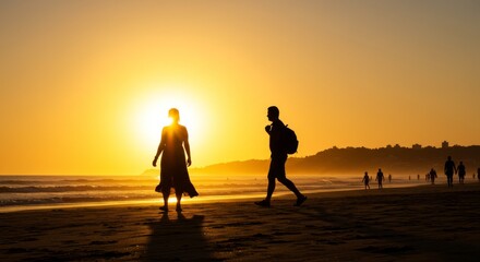 Fototapeta premium Sunset Stroll on the Beach - Silhouetted figures of a man and woman walking on a beach at sunset. Golden hour light creates a dramatic scene