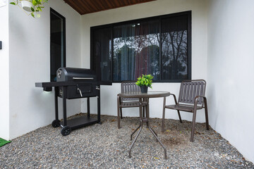 Outdoor patio with barbecue grill and metal table with two chairs