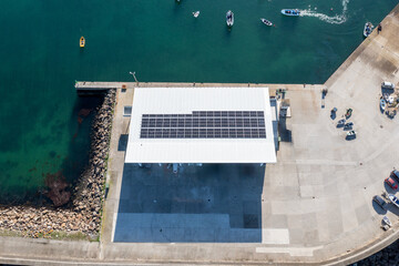 Solar panels generating green energy on a harbor warehouse roof