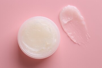 Moisturizing lip balm and jar on pink background, top view