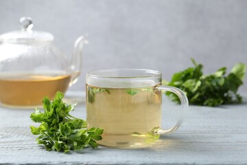 Healthy parsley tea on grey wooden table. Detox drink