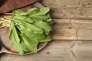 Fresh green sorrel leaves on wooden table, top view. Space for text