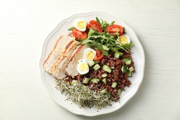 Delicious salad with brown rice on white wooden table, top view