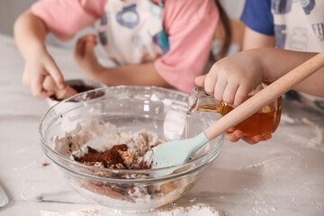 Cooking recipe. Cute children making dough for cookies at table in kitchen, closeup