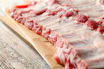 Raw pork ribs on wooden table, closeup