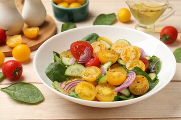 Fresh salad with yellow tomatoes served on wooden table, closeup