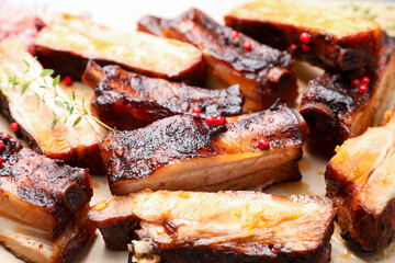 Delicious pork ribs and thyme on parchment paper, closeup © New Africa