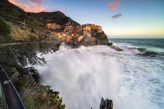 Mareggiata al tramonto sulla scogliera del borgo di Manarola, Parco Nazionale delle Cinque Terre, comune di Riomaggiore, provincia della Spezia, Liguria, Italia, Europa