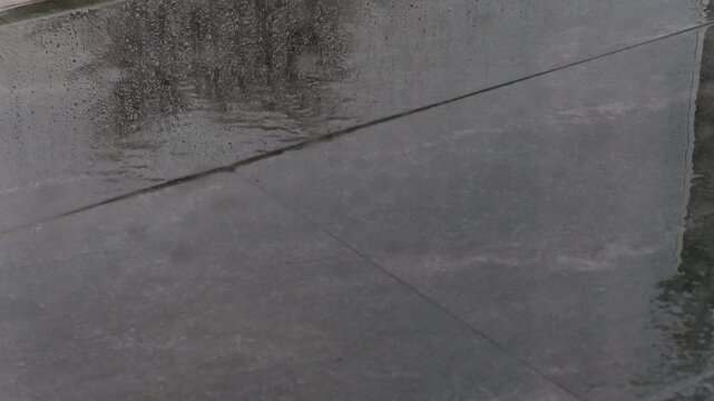 Chuva a cair no ch&atilde;o de pedra cinza com camara est&aacute;tica