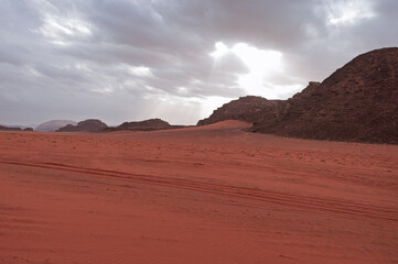 A desert landscape with a large hill in the background
