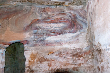 A wall with a green stain and a brown and white swirl pattern
