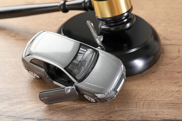 Auto accident law. Judge's gavel and toy car on wooden table, closeup