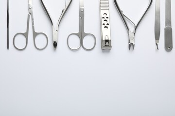 Set of different manicure tools on white background, flat lay. Space for text