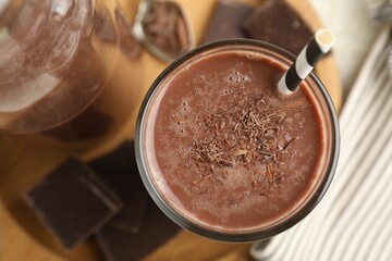 Tasty chocolate milk with shavings and pieces on table, top view
