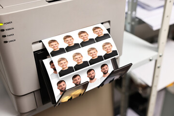 Modern printer with passport photos of man and child indoors, closeup