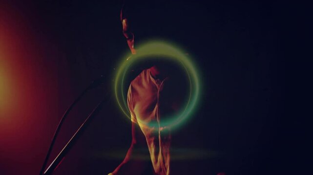Male singer singing into microphone in music tech studio, with neon green-yellow light ring overlay