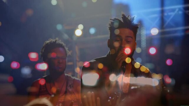 Lead singer singing into mic, backing vocalist harmonizing with bokeh lights over truss for music