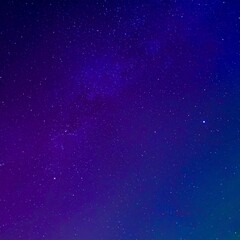 Obraz premium 深い紫と青の色合いが広がる宇宙空間、星々が煌めき、神秘的なオーロラが空間を包み込む幻想的なシーン