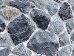 A textured wall made of various gray stones, showcasing different shapes and sizes with a natural, rugged appearance.