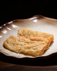 A plate of fried food sits on a wooden table