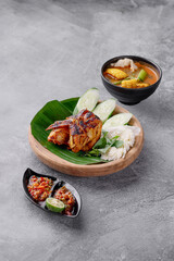 A plate of food with a bowl of soup in the background