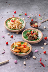 Three bowls of food with a variety of dishes including a bowl of noodles