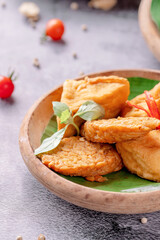 A plate of fried food with a green leaf on top