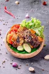 A bowl of food with meat and vegetables