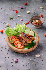 A plate of food with meat and vegetables on a wooden plate