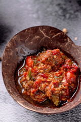 A bowl of food with a lot of red sauce and green peppers