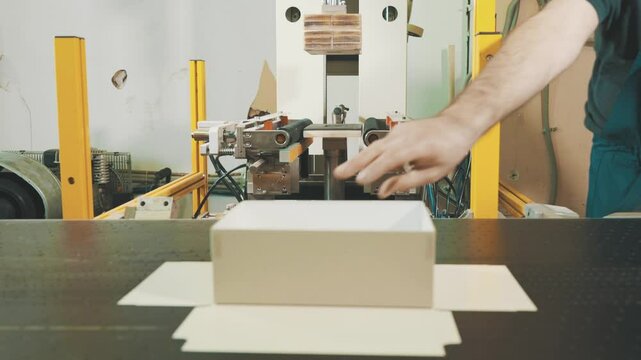 Automated laminating machine efficiently processes rectangular boxes in a dynamic workspace environment