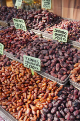 Various types of dates displayed for sale at a market stall
