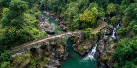stone footbridge spanning a turquoise rainforest river, framed by giant ferns and hanging vines, multiple waterfalls tumbling down rocky cliffs into the pool below