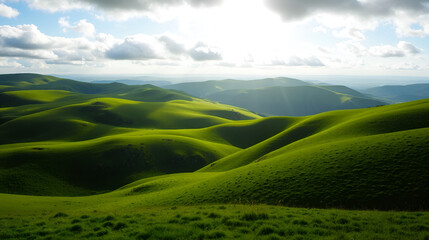 Fototapeta premium Stunning green landscape with rolling hills under a cloudy sky and sun shining brightly, perfect for nature and travel imagery.