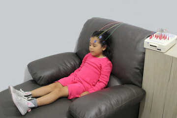 Electroencephalogram, a test that measures the brain's electrical activity, recording the brain waves of a 5-year-old Latina girl to diagnose autism or ADHD