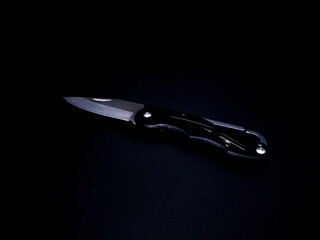folding knife on black background