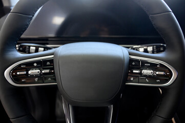 A close-up of a modern car's steering wheel with control buttons