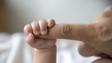 Tender Touch: A newborn's tiny hand clutches the finger of an adult, symbolizing a beautiful bond of tenderness and love. This close-up shot encapsulates the purity and innocence of a baby's touch.
