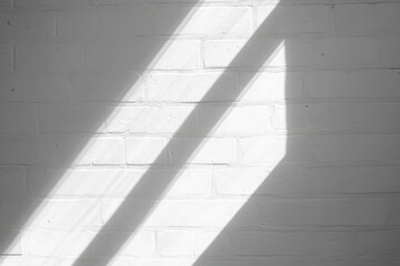Obraz premium Sunlight casts diagonal shadows on a white brick wall