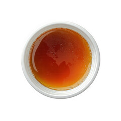 a round. white container filled with a rich. amber-colored liquid the surface appears smooth with some bubbles. suggesting a viscous texture this could represent a food item. potentially a sweetener o