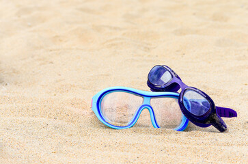 Diving goggles on the sand at the seaside.