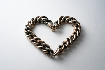 Obraz premium Oxidized Silver Chain Fashioned Into A Love Heart Shape On White Backdrop For Use In Design Projects