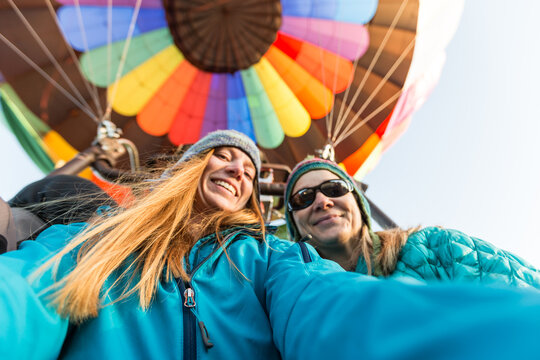 Low angle selfie of two smiling women on a hot air balloon ride together