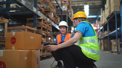 Warehouse Workers Scanning Packages with Handheld Device in Distribution Center